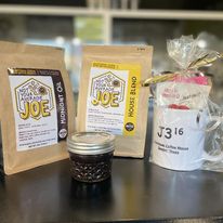 Bags of J316's house coffee beans next to a J316 gift mug.